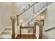 Elegant staircase with wood railings, carpeted steps, and decorative table with a lamp at 15235 W Iliff Ave, Lakewood, CO 80228