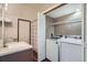 Bathroom and laundry room with white washer and dryer, and a shower/tub combo at 1661 S Fulton St, Aurora, CO 80247