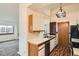 Galley kitchen featuring stainless appliances, white cabinets, and wood look flooring at 1661 S Fulton St, Aurora, CO 80247