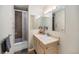 A functional bathroom with a shower-tub combo, vanity and sink with a decorative mirror and tile flooring at 895 Vance St, Lakewood, CO 80214