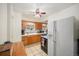 Traditional kitchen featuring wood cabinets, tiled floors, and a white refrigerator at 895 Vance St, Lakewood, CO 80214