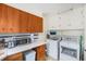 This functional laundry room includes both a washer and dryer, with cabinets for storage and countertop appliances at 895 Vance St, Lakewood, CO 80214