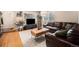 Cozy living room with hardwood floors, a comfortable leather sofa, and a modern media center at 895 Vance St, Lakewood, CO 80214