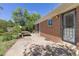 Exterior view of a brick house with backyard access and picnic table on the patio at 430 S Potomac Cir, Aurora, CO 80012