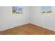 Bedroom with hardwood floors, white walls, and two windows at 430 S Potomac Cir, Aurora, CO 80012