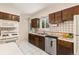Bright kitchen featuring tile counters and backsplash, white appliances, and wood cabinets at 430 S Potomac Cir, Aurora, CO 80012