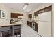 Traditional kitchen with wood cabinets, white appliances, tile backsplash, and tile floors at 430 S Potomac Cir, Aurora, CO 80012