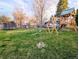 Backyard featuring a grassy lawn, play structure, and trampoline, offering a private outdoor space at 3326 S Geneva St, Denver, CO 80231