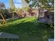 Spacious backyard with a trampoline, wooden play structure, and lush green lawn at 3326 S Geneva St, Denver, CO 80231