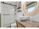 Bathroom featuring a stand alone sink, rustic vanity, sliding glass shower doors, and wood-like mirror at 3326 S Geneva St, Denver, CO 80231