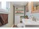 Cozy bathroom with a unique sink, decorative mirror, storage shelves, and stylish design elements at 3326 S Geneva St, Denver, CO 80231