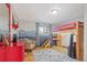 Fun bedroom with a bunk bed, accent wall, colorful rug, and a dresser with red accents at 3326 S Geneva St, Denver, CO 80231