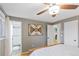 Bedroom with hardwood floors, gray walls, a ceiling fan, and bathroom access at 3326 S Geneva St, Denver, CO 80231