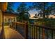 A luxurious wooden deck highlights secure dark metal railings with accent lights against a beautiful sunset backdrop at 150 Hess Ave, Golden, CO 80401