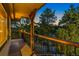 Outdoor deck area shows black railings and is framed by mature pine trees and a peek of the sunset at 150 Hess Ave, Golden, CO 80401