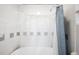 Clean bathroom features a shower with a blue curtain and white tile walls at 215 E 11Th Ave # D5, Denver, CO 80203