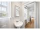 Bright bathroom with pedestal sink and window, offering a clean and classic design at 215 E 11Th Ave # D5, Denver, CO 80203