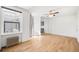 Bright living room with hardwood floors, classic radiator, ceiling fan, and access to other parts of the home at 215 E 11Th Ave # D5, Denver, CO 80203