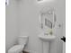 Powder room featuring a pedestal sink, oval mirror and elongated toilet set against a bright wall at 20999 E Quincy Dr, Aurora, CO 80015