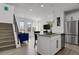 Modern kitchen featuring an island, stainless steel appliances, white cabinets, and open-concept design to living spaces at 20999 E Quincy Dr, Aurora, CO 80015