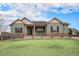 Charming single-story home with a covered porch, manicured lawn, and stone accents at 23440 E Rockinghorse Pkwy, Aurora, CO 80016