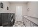 Laundry room with modern washer/dryer, checkered floors, utility sink, and counter space at 23440 E Rockinghorse Pkwy, Aurora, CO 80016
