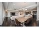 Open-concept living and dining area featuring a large TV, comfortable seating, and modern lighting fixtures at 23440 E Rockinghorse Pkwy, Aurora, CO 80016