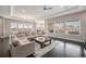Spacious living room with large windows, ceiling fan, hardwood floors, and comfortable sectional sofa at 23440 E Rockinghorse Pkwy, Aurora, CO 80016