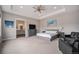 Spacious main bedroom with tray ceilings, a king-sized bed, and a view into the ensuite bathroom at 23440 E Rockinghorse Pkwy, Aurora, CO 80016