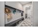 Mudroom with built-in bench, storage shelves, and checkered flooring leading to laundry area at 23440 E Rockinghorse Pkwy, Aurora, CO 80016