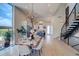 Open dining area featuring a chandelier, modern table, and access to the kitchen and staircase at 5125 W 29Th Ave # 1, Denver, CO 80212
