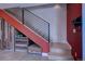 Unique staircase with storage features a bold red accent wall and black metal banister at 5125 W 29Th Ave # 1, Denver, CO 80212
