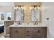 Elegant bathroom with a double vanity, stone backsplash, modern lighting, and dual mirrors at 937 Aztec Dr, Castle Rock, CO 80108