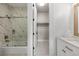 Bright bathroom featuring a marble tiled shower-tub and vanity at 937 Aztec Dr, Castle Rock, CO 80108