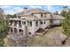 Back view of luxury home featuring a large patio, expansive windows, and meticulously maintained landscaping at 937 Aztec Dr, Castle Rock, CO 80108