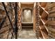 Stone-walled wine cellar with wooden shelving and accent lighting at 937 Aztec Dr, Castle Rock, CO 80108