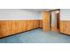 Unfinished basement with wood paneling and blue carpet, offering potential for customization at 40 Colorado Blvd, Denver, CO 80206