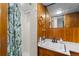 Bathroom features a shower with green shower curtain and wood paneled walls at 40 Colorado Blvd, Denver, CO 80206