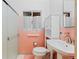 Updated bathroom featuring retro pink tile and a frosted glass shower door at 40 Colorado Blvd, Denver, CO 80206