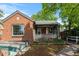 Quaint brick home featuring a welcoming covered front porch and unique arched detail over the below grade garage access at 40 Colorado Blvd, Denver, CO 80206