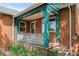 Inviting covered front porch with brick columns, charming trim, and a classic white railing and space for seating at 40 Colorado Blvd, Denver, CO 80206