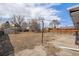 Large backyard has a mix of concrete and dry grass and mature trees ready for landscaping at 6185 Sheridan Blvd, Arvada, CO 80003