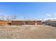 Wide view of a brick home and backyard with sliding glass doors and door leading to the backyard space at 6185 Sheridan Blvd, Arvada, CO 80003