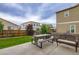 Inviting backyard with a picnic table, rattan seating, and well-maintained lawn at 6883 E 132Nd Pl, Thornton, CO 80602