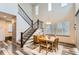 Elegant dining room with staircase, modern lighting and wood floors at 6883 E 132Nd Pl, Thornton, CO 80602