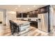 Bright kitchen boasts stainless steel appliances, granite countertops, a stylish island, and dark wood cabinets at 6883 E 132Nd Pl, Thornton, CO 80602