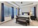 Main bedroom featuring tray ceilings, large windows, and stylish, blue curtains at 6883 E 132Nd Pl, Thornton, CO 80602