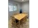 Dining room with light wood table and six chairs, brightened by a window view at 9041 Lilly Ct, Thornton, CO 80229