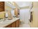 Bathroom featuring a double sink vanity, neutral walls, and a shower with a curtain at 12165 Monaco Dr, Brighton, CO 80602