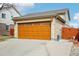 Side view of the garage and a section of the brick home with a wooden fence at 12165 Monaco Dr, Brighton, CO 80602